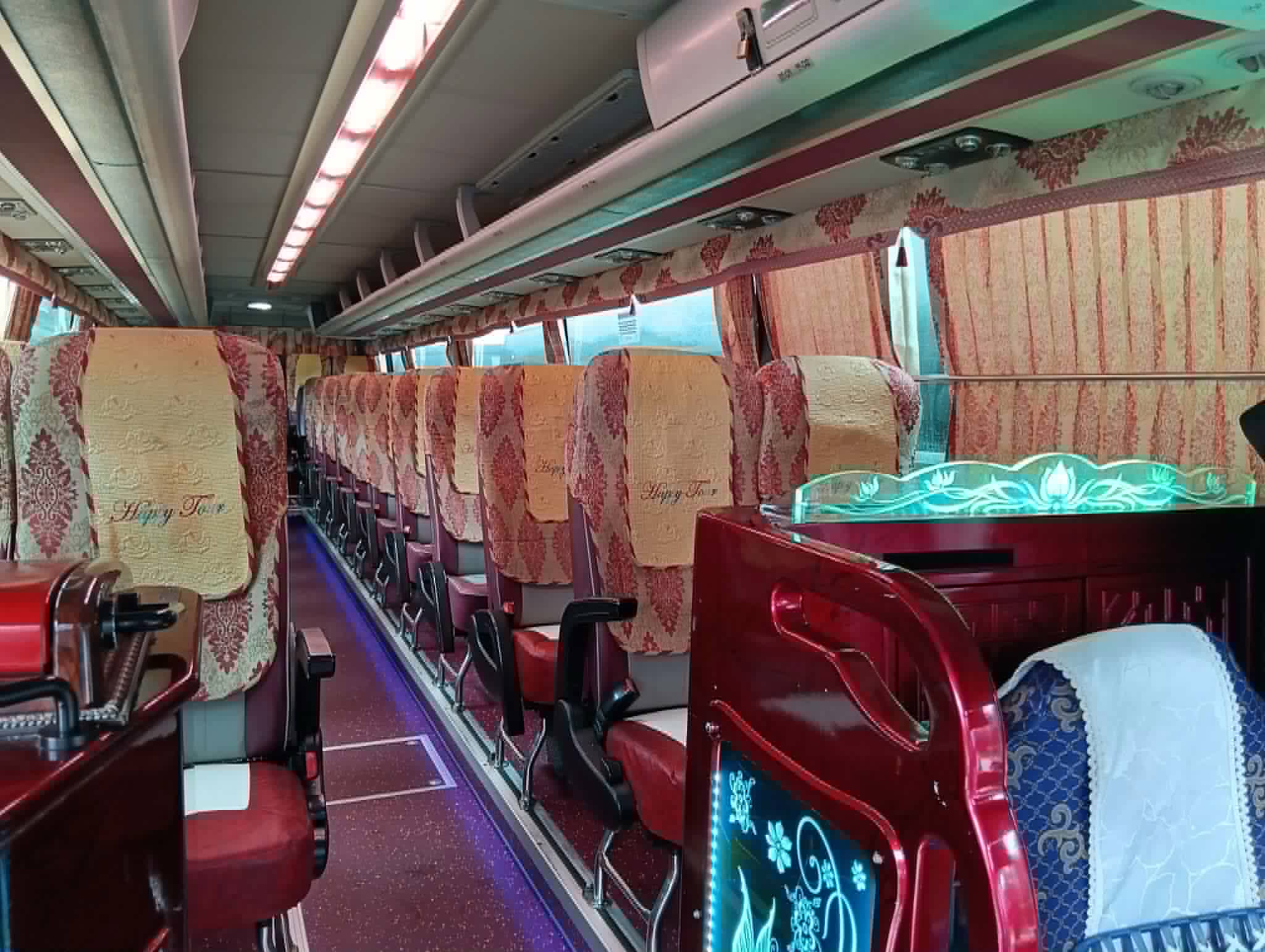 Cabin seen from the front row: seats along the aisle with the guide's seat and its lit glass panel in the foreground.